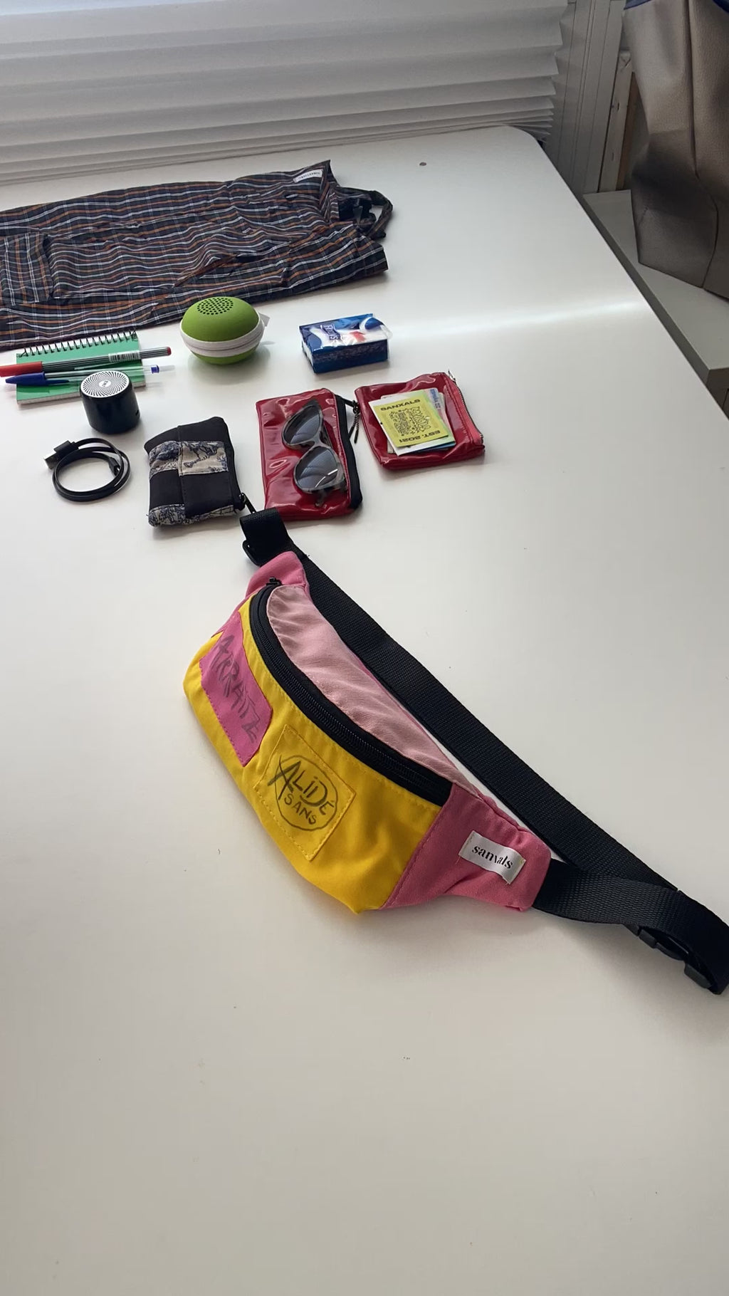 Video de cosas que caben en la riñonera 2 monederos, gafas con estuche, altavoz bluetooth, 2 boligrafos, 1 libreta, 1 bolsa de tela, airpods, 1 paquete de kleenex
