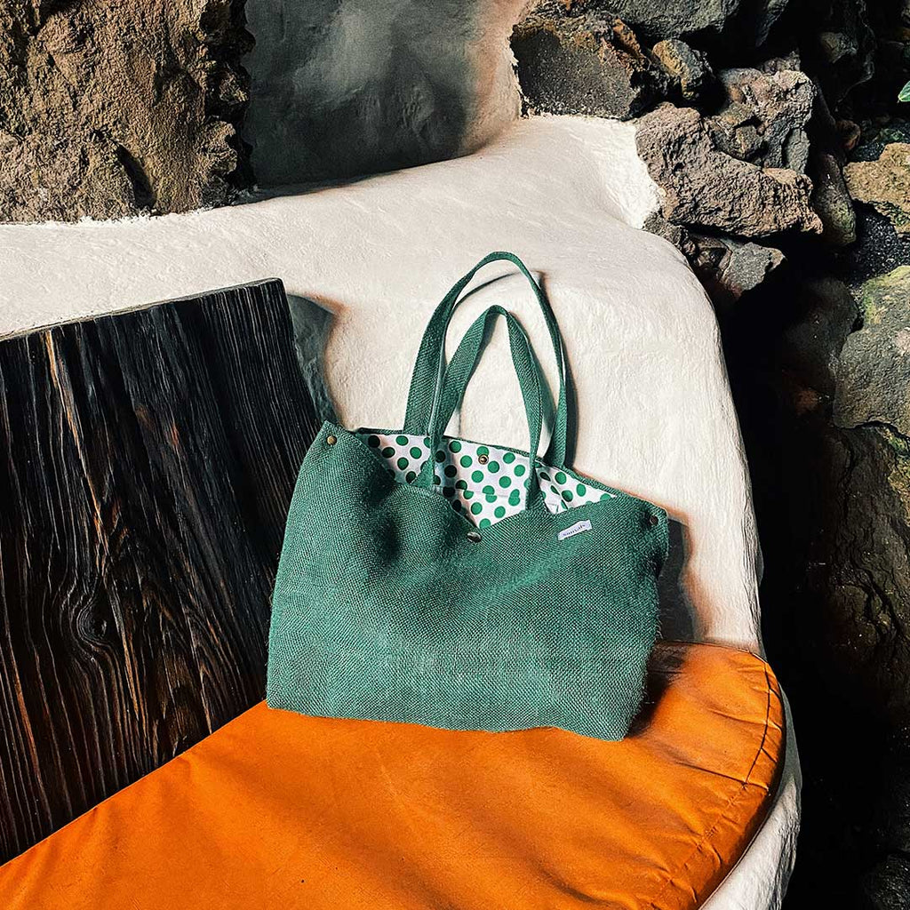 bolso sobre asiento rústico y piedras volcánicas de Lanzarote, vista interior de los topos verdes, que evocan un aire alegre