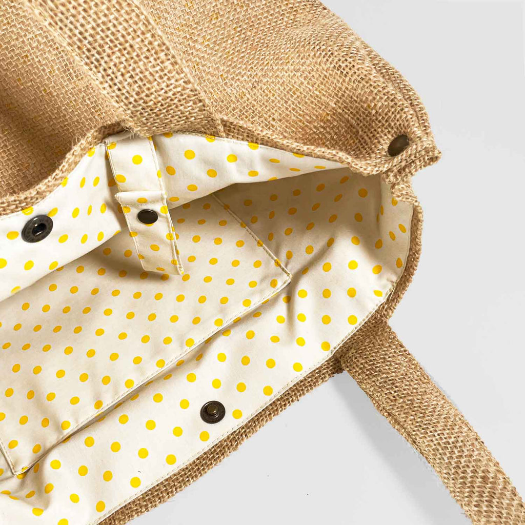 Detalle del interior del bolso lunares amarillos con fondo blanco, bolsillo interior y detalle de cinta para colgar las llaves