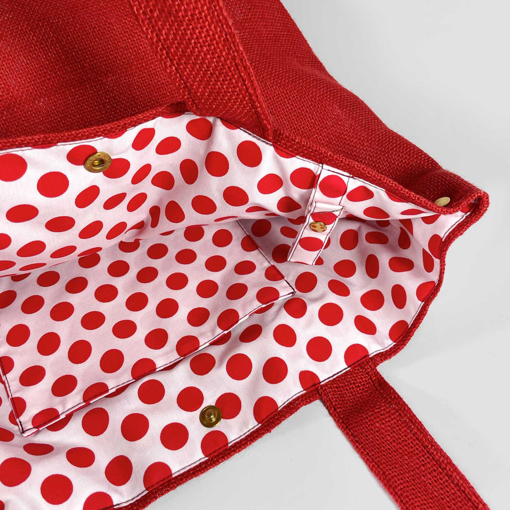 detalle del interior lunares rojos con fondo blanco, bolsillo interior y detalle de cinta para colgar las llaves