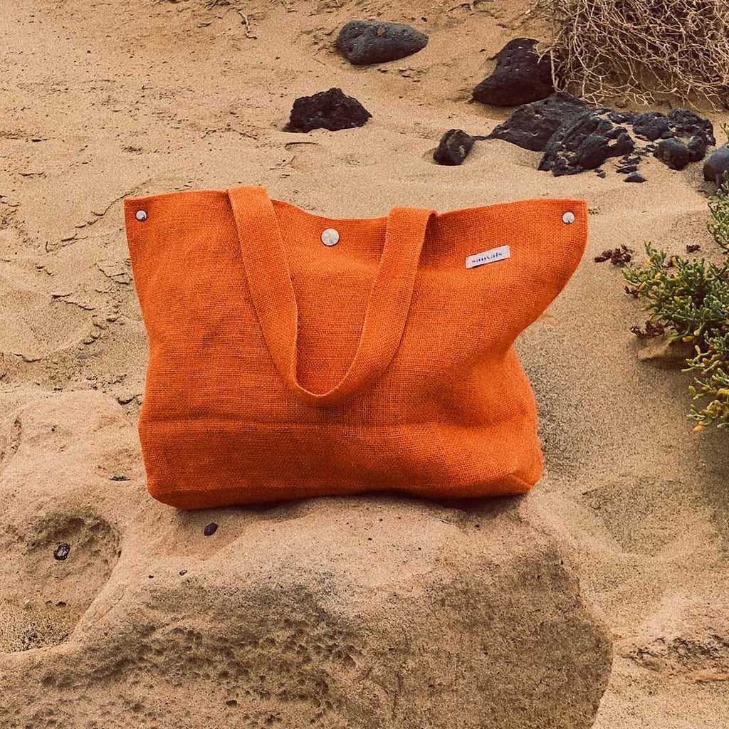 Bolso naranja, con fondo arena playa
