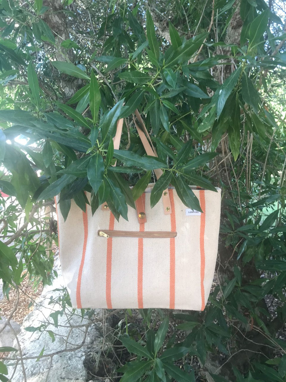 foto del bolso en Menorca, junto un árbol de verde intenso